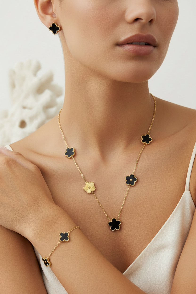 Woman wearing black gold clover single strand set