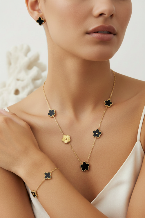 Woman wearing black gold clover single strand set